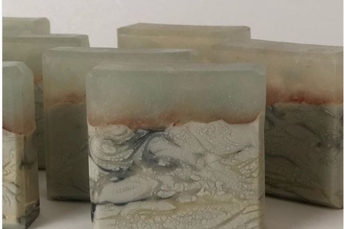 Cut cold process soap bar showing pale vein-like glycerin river patterns