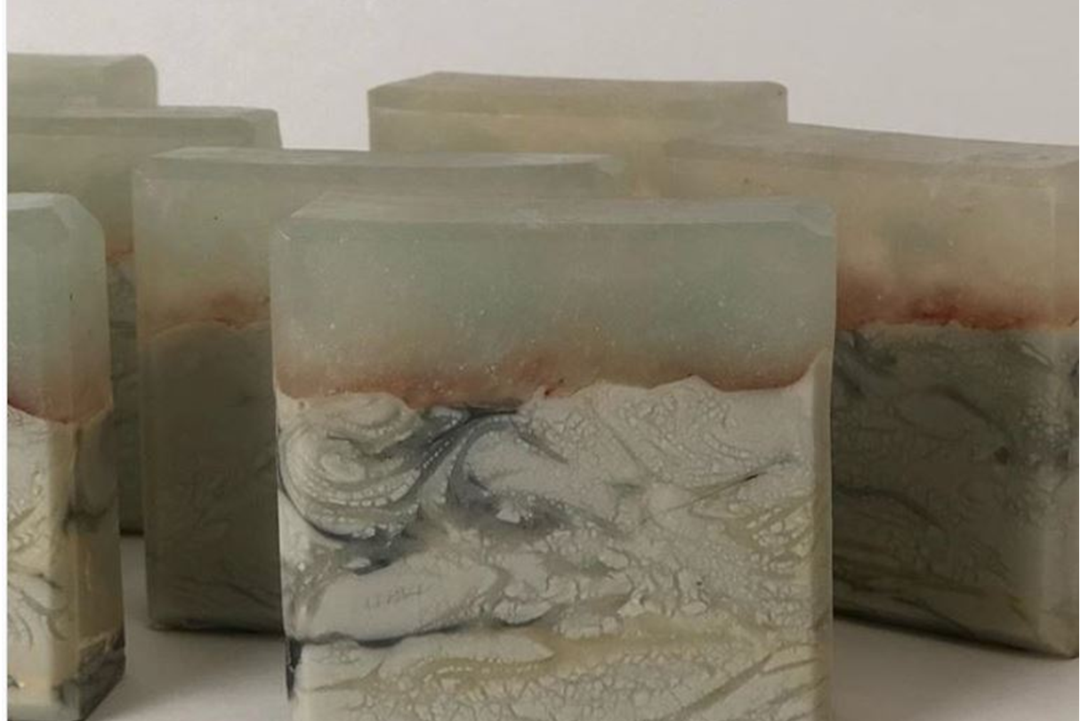Cut cold process soap bar showing pale vein-like glycerin river patterns